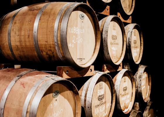 Barriques de vin entreposées les unes sur les autres.