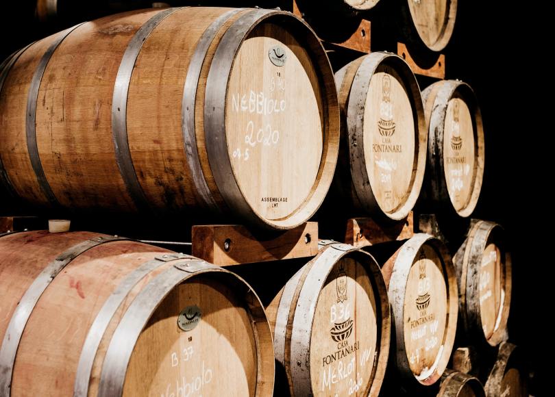 Barriques de vin entreposées les unes sur les autres.